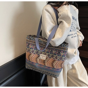 Detail shot of the ethnic pattern texture and sturdy woven straps on the large tote bag