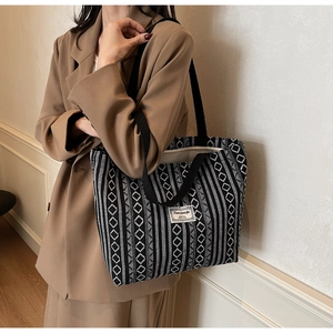 Detail of large ethnic geometric tote bag with black and white canvas pattern and branding