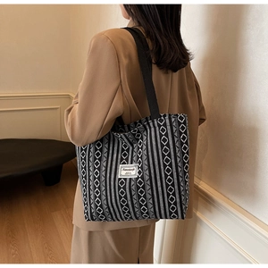 Detail of ethnic tote bag showing black and white geometric canvas pattern and brand label