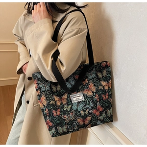 Detail of floral jacquard tote bag featuring colorful butterfly patterns and woven label