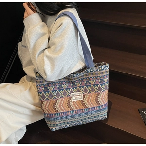 Detail of colorful ethnic woven tote bag with geometric patterns and brand fabric label