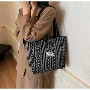 Black and white geometric tote bag shown on a model's shoulder for a commuter style