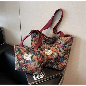 Détail du sac cabas en tapisserie florale rétro avec poignées bordeaux et étiquette