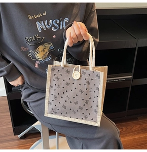 Détail du sac cabas en toile de jute avec imprimé papillon cœur et bouton rond en bois