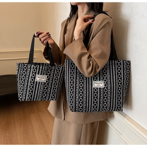 Detail view of large and small ethnic tote bags with black and white geometric patterns