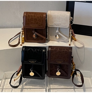 Detailed view of leopard print crossbody phone bags with beaded straps and gold charms