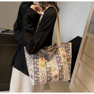 Détail d'un sac cabas tissé ethnique avec motifs géométriques et anses solides d'épaule