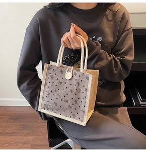 Détail du sac en lin avec panneau en velours côtelé gris, imprimé cœur et bouton blanc