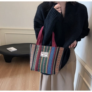Detailed close-up of ethnic woven pattern and fabric label on a vintage tote bag