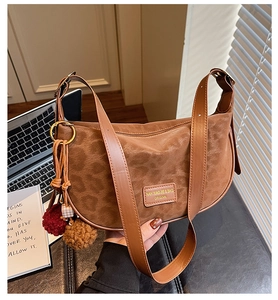 Détail du sac demi-lune léopard avec pendentif en peluche sur fond de bureau urbain