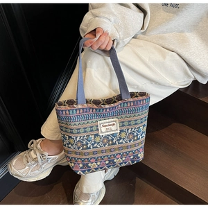 Detailed shot of ethnic woven tote bag with colorful geometric patterns and fabric handle