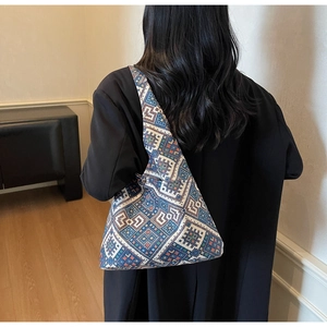 Borsa tote etnica con motivi geometrici colorati mostrata sulla spalla di una modella