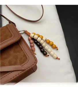 Détail du sac léopard vintage avec pompon en perles de bois et texture en daim doux