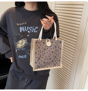 Détail du sac cabas gris en toile avec nœuds noirs et poignée en corde de coton