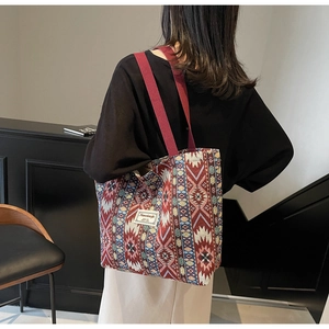 Détail du sac cabas tissé au motif ethnique avec larges poignées en toile bordeaux