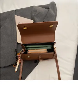 Vue détaillée de l'intérieur du sac à bandoulière rétro marron avec téléphone et perles