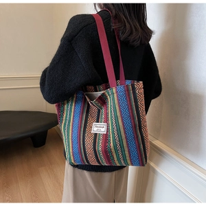 Close-up of ethnic tote bag showing colorful geometric patterns and burgundy strap