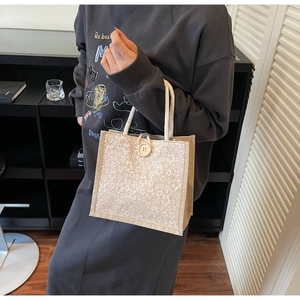 Detailed close-up of beige linen lunch tote bag with white lace floral embroidery details