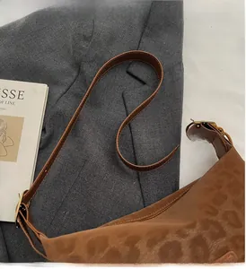 Gros plan du sac léopard en daim marron avec bandoulière en cuir réglable dorée