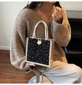 Détail du sac en lin avec motifs cœurs blancs, nœuds et un bouton crème élégant
