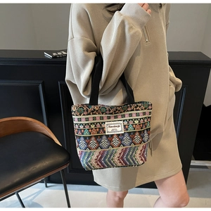 Close-up of ethnic woven tote bag featuring vibrant geometric patterns and black handles