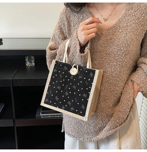 Détail d'un sac à lunch en lin noir avec motifs cœurs et poignées en corde tissée