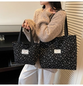Vue détaillée du lot de sacs fourre-tout en toile noire à motifs cœurs et nœuds