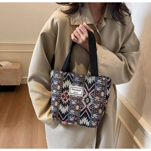 Détail du sac cabas ethnique avec motifs géométriques colorés et étiquette de marque