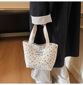 Détail du sac cabas en velours côtelé avec motifs de cœurs et nœuds et étiquette tissée