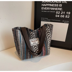 Detail of woven ethnic tote bag featuring bohemian geometric patterns and fabric label