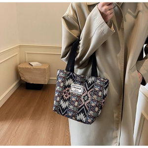 Texture détaillée du sac cabas en tissu jacquard ethnique avec motifs géométriques sur la bandoulière