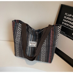 Detail of ethnic woven tote bag featuring colorful geometric patterns and canvas handles