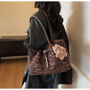 Detail view of large tote bag with brown leopard and rose pattern and bear charm