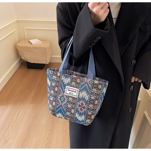 Gros plan sur le fourre-tout ethnique avec motifs géométriques bleus et écusson de marque