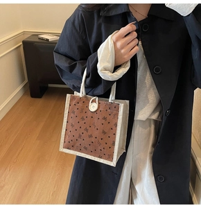 Détail du sac à lunch en lin avec tissage en jute, imprimé papillon et bouton de fermeture