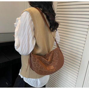 Gros plan détaillé du sac hobo à motif léopard marron foncé avec bandoulière en cuir