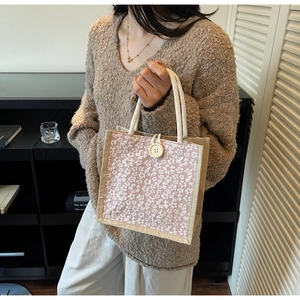 Detailed shot of lace floral tote bag with woven handles and large button closure