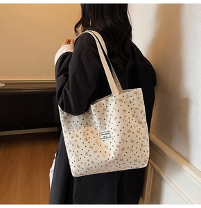 Détail du sac cabas en velours côtelé avec motifs de nœuds bruns et tissu texturé