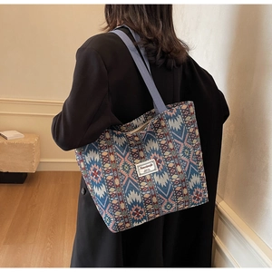 Close-up of the ethnic geometric jacquard fabric and brand label on a large tote bag