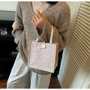 Close-up of pink linen lunch bag with white lace floral overlay and large button detail