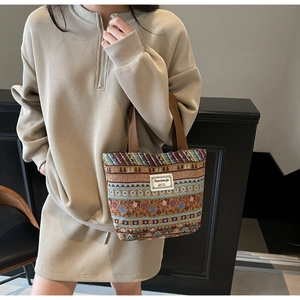 Detail of colorful ethnic jacquard tote bag with durable woven handles and brand label
