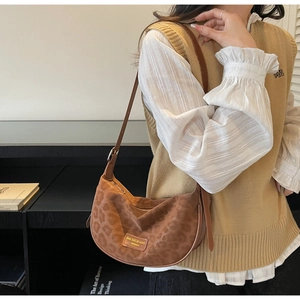 Détail du sac hobo léopard marron avec logo doré et texture en daim de haute qualité