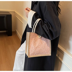 Detailed close-up of pink lace floral handbag with woven rope handle and round white buckle