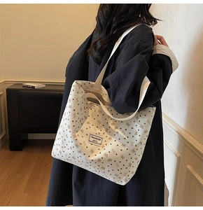 Détail du sac cabas en velours côtelé crème avec motifs cœurs et logo nanciao