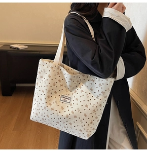 Détail du sac cabas en velours côtelé avec motifs cœurs marron et écusson de marque