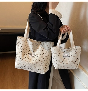 Detail of beige canvas tote set with pink bow and heart prints with fine texture