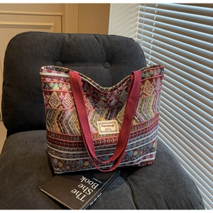 Close-up of Bohemian canvas tote bag with geometric patterns on a grey velvet chair