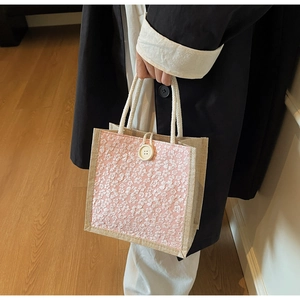 Detail of pink floral lace linen lunch bag with rope handles and button closure