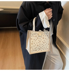 Détail du sac à lunch en lin avec nœuds roses, motifs de cœurs et poignées en corde de coton
