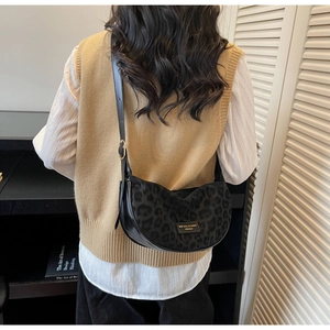 Sac bandoulière imprimé léopard porté par un mannequin avec détail logo en métal